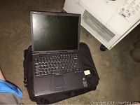 Open Dell Latitude CPX Model PPX laptop placed on top of the black carrying case, showing keyboard and screen.