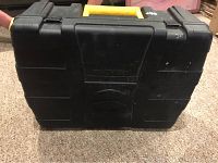 Closed black plastic case with yellow handle labeled Wagner, has minor scuffs and marks.