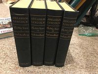 Four volume set of Abraham Lincoln: The War Years by Carl Sandburg. Black hardcover books placed side by side showing titles and volume numbers on spines.