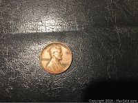 Close-up of the obverse of the 1957 D Lincoln Wheat penny showing the filled B in LIBERTY and reddish toning.