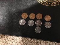 Photo showing 8 pennies arranged in two rows - 4 steel pennies on bottom row, 4 wheat pennies on top row.