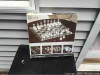 Photo of the box showing the JC Penny 5 in 1 glass game set with chess pieces arranged on the glass board