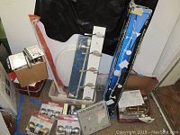 Photo showing a variety of items including a towel bar, boxed faucets, track light in packaging, faucet installation tools, and an LCD adapter plate.