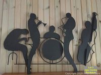 Full view of black metal wall art depicting jazz combo band with trumpet, drummer, saxophone, and double bass players.