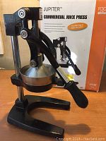 Focus Jupiter commercial juice press on wooden surface with original box in background