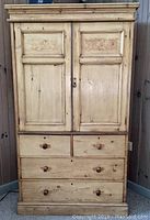 Front view of solid pine antique linen press showing full cabinet and drawers.