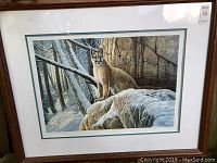 Full view of framed 'First Snowfall' print featuring cougar in snowy forest.