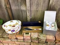 Overview of covered casserole, cake server in box, salt and pepper shakers in box on brick ledge