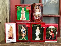 Photo showing six Marilyn Monroe Christmas figurine ornaments in original retail boxes, variety of styles including white dress, red dress and phone pose.