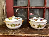Two covered dishes side by side on wooden surface in front of window