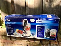 Box for Oster 11 cup food processor and 3 cup mini chopper showing product images and features