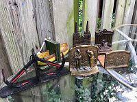Wide shot of all bookends showing two pairs of metal anchors, cast resin boats, and three individual metal bookends with sculptural reliefs