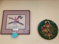 Framed floral print and round dyed fabric wall art photographed on a wall showing their color and design details