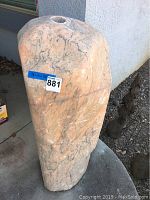 Front angle showing orange and gray veined stone with a hole drilled at the top center.