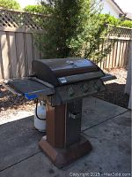 Full side view of brown Kenmore gas barbecue grill showing side shelves, pedestal base, and grill body with lid closed.