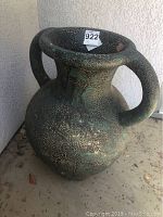 Front angle view of large green crackled ceramic pot with handles, showing full height and textured finish.