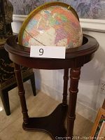 Photo showing full stand with mounted globe labeled with lot number 9, highlighting wooden tripod stand and globe size.