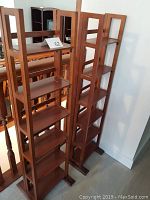 Two wooden book towers side by side showing front and part of side detail.