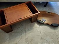 Wooden lap desk with storage compartments and flat lap tray with handles photographed on floor.