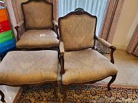 Wide view of two chairs and ottoman on area rug