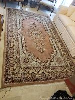 Full view of the large rectangular floor rug laid out in living room setting with furniture.