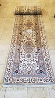 Full view of the rolled-out hall runner on tile floor showing border and fringe