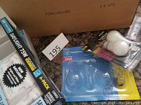 Box of various lightbulbs including boxed 13W daylight CFLs, a blister pack of 60W Westinghouse fan bulbs, and loose incandescent bulbs.