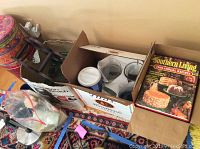 Photo of boxed cookbooks including Southern Living Annual Recipes editions and other kitchen items like tins and wine rack.