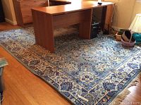 Wool area rug under a large desk showing overall design and scale of rug in room.