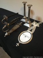 Overview of all 7 silver colored home accessory items: 2 wall sconces, 2 candle holders, 2 candles, and 1 picture frame with ribbon.