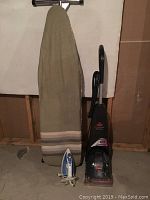 Photo of the ironing board, household iron, and Bissell vacuum.