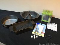 Overview of all items showing the three baking pans, the green vegetable chopper, the icing kit, and cookie cutter.