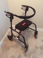 Full view of the walker showing padded seat, cushioned oval handlebar, and brake handles.