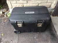 Closed view of the Stanley large 24 gallon black rolling tool box showing metal latches and wheels