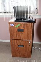 Photo of woodgrain 2-drawer file cabinet with clear plastic desk organizer on top.