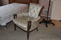 Image showing front and side view of vintage upholstered accent chair with damask pattern fabric and wooden carved legs and armrests.