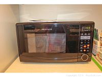 Frigidaire black microwave with digital keypad and viewing window.