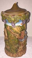 Front view of vintage Gunter Kerzen eternal candle showing hand carved scene with foliage, grapes, and engraved 'Loreley' text.