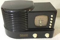 Front view of Crosley CR-1 limited edition radio showing ribbed speaker section and square dial with needle indicator and controls.