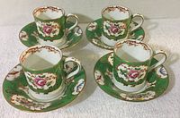 Photo of four vintage Coronet bone china cups and matching saucers, showing green, gold, and floral design.