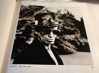 Black and white photo of Keith Richards wearing feathered hat and sunglasses inside the book.