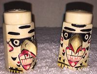 Front view of the vintage Thunderbird totem salt and pepper shakers showing detailed painted faces, beaks, and soda tops.