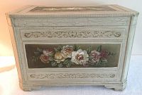 Front view of trunk showing floral painted panel, crackle finish, carved details, and feet.