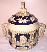Front view of the vintage ceramic Rumtopf showing castle relief design, grapevine decorations, and dual handles.