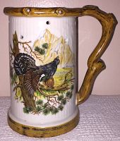 Left side view showing pheasant on tree branch with mountain background and wood effect handle and rim