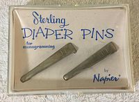 Two sterling silver diaper pins monogrammed JCL in original plastic box with card insert.