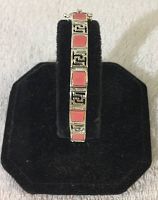Close-up of the bracelet displayed on a black stand showing the alternating silver and pink stone square links.
