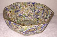 Octagonal bowl with detailed multicolor floral and paisley decoration inside and out shown from side angle illustrating shape and pattern