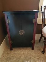 Front view of the cabinet showing black doors with red side accents and metal hardware.