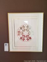 Full front view of framed artwork showing white mat, gold-tone frame, and circular design